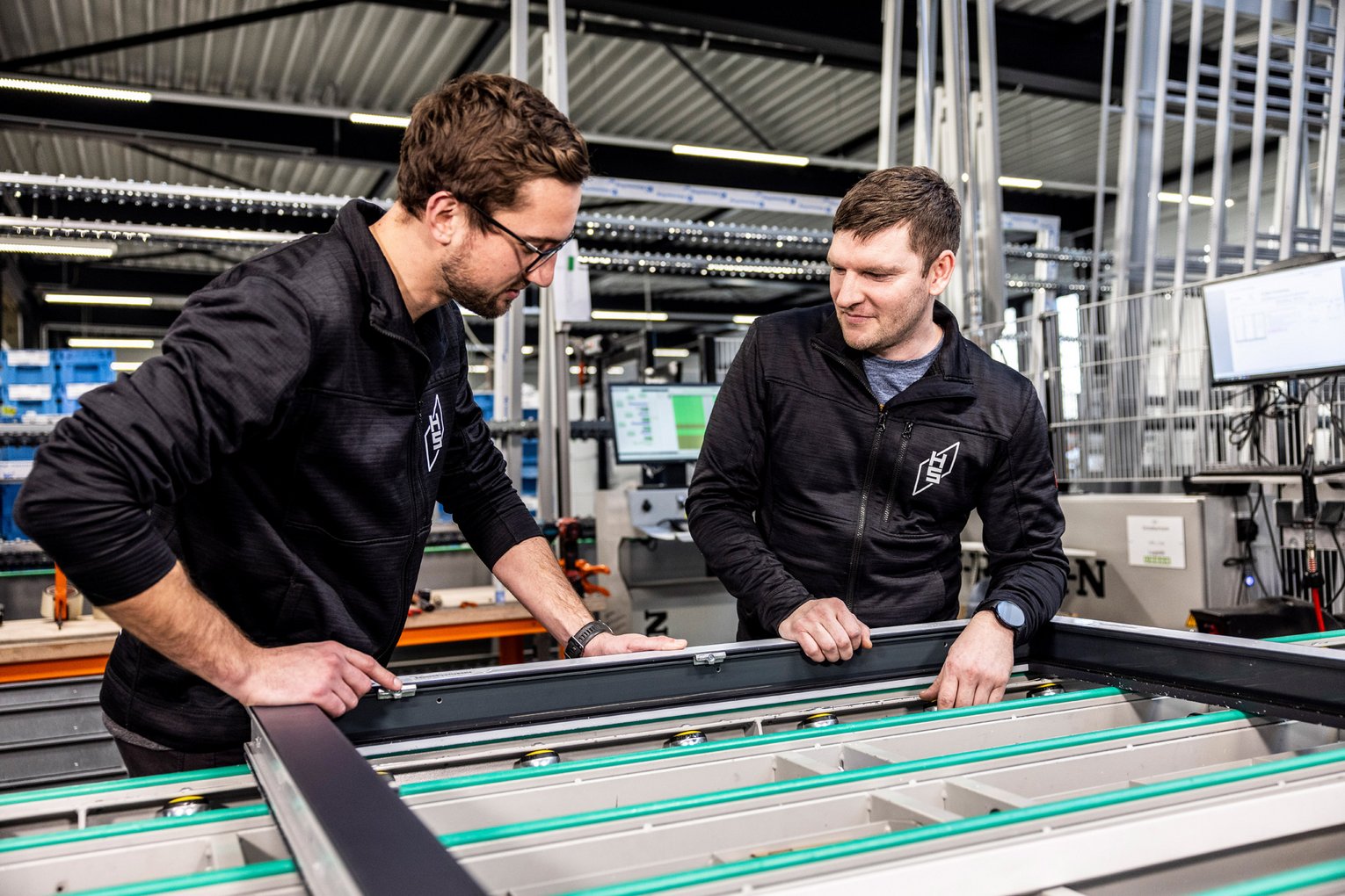 Zwei Mitarbeiter von HAUG + SCHÖTTLE arbeiten an eine Fensterrahmen